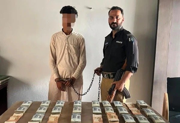 Friend Allegedly Steals Rs. 36 Million From Karachi Trader, Police Recover Cash Hidden Under Sand Karachi police officers displaying recovered Rs. 36 million cash after arresting burglary suspect.
