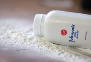 Johnson & Johnson logo displayed alongside a container of baby powder representing the company's talc lawsuit settlement.