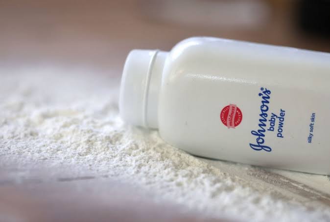 Johnson & Johnson logo displayed alongside a container of baby powder representing the company's talc lawsuit settlement.