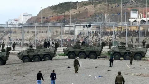 Spanish security forces deployed in Ceuta following a large migrant crossing from Morocco.