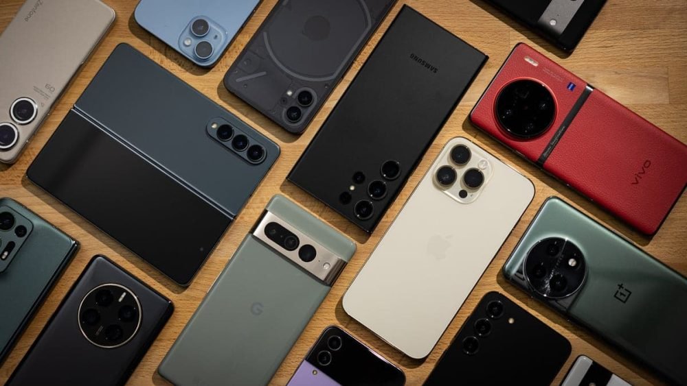 A customer comparing smartphones in a mobile phone store as global chip costs drive price concerns.
