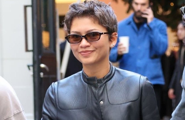 Zendaya wearing a long black vintage Prada leather trench coat with light-wash jeans, a white shirt and statement shoes during a shopping trip in Paris.